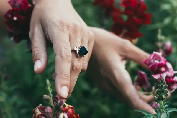 Mãos de uma bela jovem que está segurando flores — Fotografia de Stock