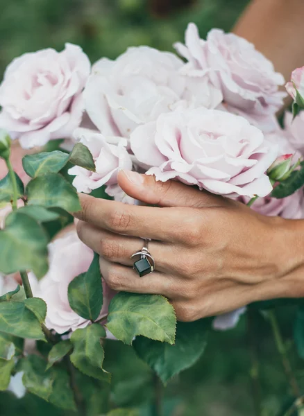 Mãos de uma bela jovem que está segurando flores — Fotografia de Stock