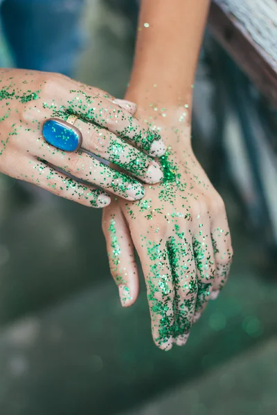 Brillo verde en las manos de las mujeres jóvenes con anillo azul — Foto de Stock