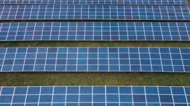 Alandaki büyük bir endüstriyel güneş paneli çiftliğinin yanında uçuyor.