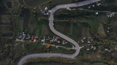 Serpentin yol trafiği boyunca giden araba ve kamyonların hava manzarası.