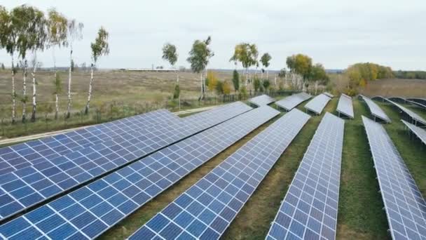 Volando cerca de una gran granja de paneles solares industriales en el campo — Vídeo de stock