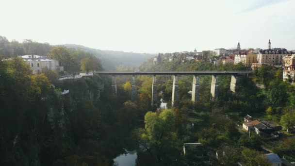 川や木と崖の上の橋の上を走行車の空中ビュー — ストック動画