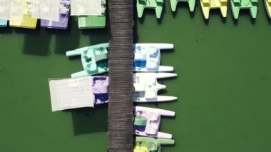 Rıhtımda arka arkaya park etmiş renkli katamaranların üzerinden uç.