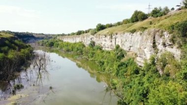 Güneşli bir günde çamurlu nehri olan eski dağ kanyonunun havadan görünüşü