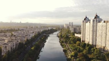 Modern gökdelenlerin ve nehir kıyısındaki eski apartmanların yakınında.