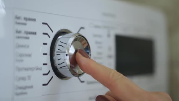 Kadın eli çamaşır makinesinin düğmesini açıp kapatıyor. — Stok video
