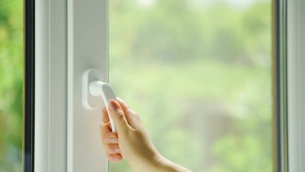 Frau öffnet morgens ein Plastikfenster in einem Raum mit Blick auf die Natur — Stockvideo