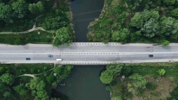 Vue de dessus des voitures et des camions passant sur le pont près de la rivière et de la forêt — Video