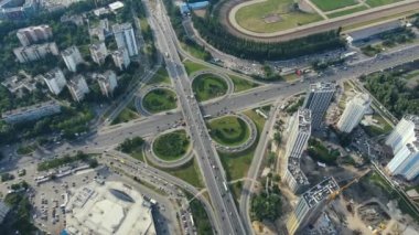 Şehir manzarasında arabaları ve kamyonları olan işlek bir trafik yolunun üzerinde uçuyor.