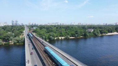 Nehir üzerindeki köprünün üzerinden geçen metro görüntüsü.