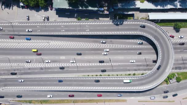 Vue aérienne de dessus des voitures conduisant le long d'une route de ville animée avec des marques et des virages — Video
