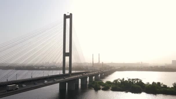 Widok z powietrza samochodów mijających duży most nad rzeką w krajobrazie miasta — Wideo stockowe
