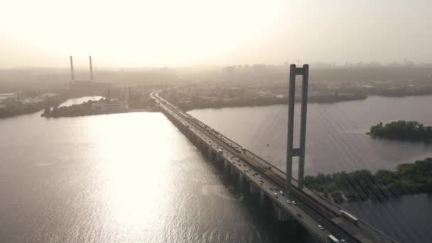 Aerial view of cars passing the big bridge over the river in the cityscape — Stock Video