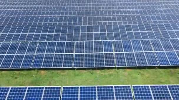 Mosca aérea sobre uma grande fazenda de painéis solares industriais construídos em uma fileira — Vídeo de Stock