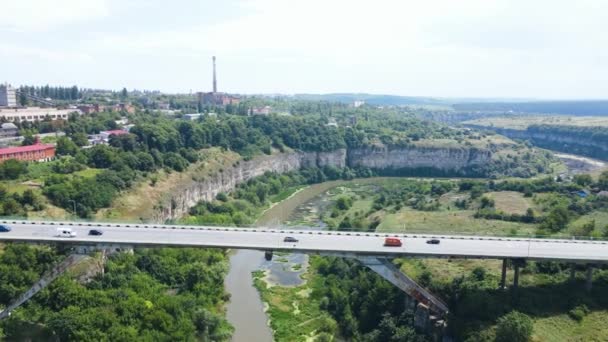 Köprüden ve dağlardan geçen trafik arabalarının hava görüntüsü. — Stok video