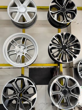 Otomobil servis galerisinin duvarında modern alaşım tekerlekleri sergileniyor. Tekerlek seçimi, araba özelleştirme, otomotiv perakendecisi, lastik dükkanı iç ve profesyonel araç geliştirme hizmetleri kavramı.