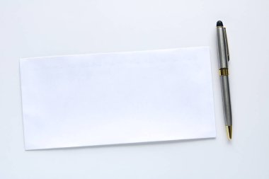 Tek bir boş beyaz zarf parlak gümüş ve altın bir kalemin yanına yerleştirilmiş, temiz beyaz bir arka planda izole edilmiş..