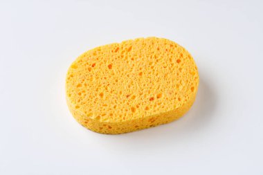 Tek bir sarı selüloz sünger. Gözenekli bir dokusu var. Temizlik ve banyo için kullanılıyor..