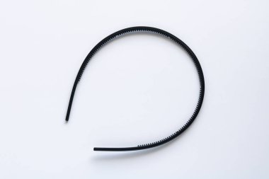 Saç şekillendirme ve saçı yerinde tutmak için basit bir saç aksesuarı veya plastik saç bandı, temiz beyaz bir arkaplanda serili..