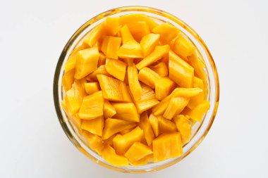 Taze, parlak sarı kaya meyvesi parçalarıyla dolu cam bir kasenin genel fotoğrafı..