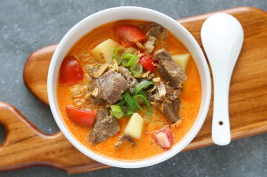 Lezzetli bir tas Soto Betawi 'nin üst manzarası. Taze soğanla süslenmiş yumuşak et, domates, patates parçaları ve kalın, kremalı bir çorba karışımını vurguluyor..