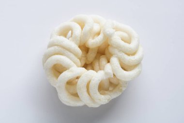 Kerupuk putih olarak bilinen beyaz, yuvarlak bir krakerin yukarıdan görünüşü karmaşık spiral şekillerini ve çıtır çıtır dokusunu gözler önüne seriyor..