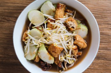 Lontong Balap, geleneksel bir Endonezya yemeği olan lontong pirinç kekleri, fasulye filizi, kızarmış tofu, lentho (perkedel kacang tolo) ve mayalanmış karides ezmesi (petis) ile yapılan bir et suyu.).