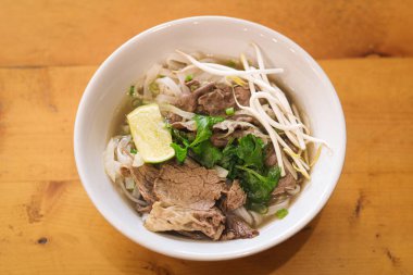 Tipik Vietnam usulü biftek dilimleri (pho bo), pirinç eriştesi ve aromatik otlar hafif, aromalı et suyu..