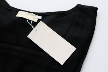 Siyah elbisedeki boş beyaz etiket, özel bir logo ya da tasarım modeli için hazır..