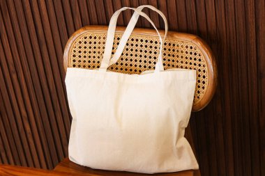 Basit, minimalist ve çevre dostu bir çanta sandalyede dinleniyor, gündelik ve sürdürülebilir bir yaşam tarzı için mükemmel..