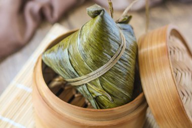Bambu yapraklarına sarılmış ve iple bağlanmış geleneksel bir Çin pirinç köftesi olan Zongzi 'nin (Bacang) yakın plan görüntüsü. Bu pirinç hamuru geleneksel bir Çin yemeğidir.. 