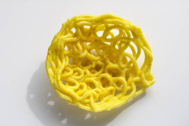 Bir Kerupuk Mie Keriting, ya da beyaz arka planda izole edilmiş kıvırcık sarı erişte krakerleri..