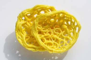 İki Kerupuk Mie Keriting, ya da beyaz arka planda izole edilmiş kıvırcık sarı erişte krakerleri..