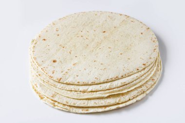 Temiz beyaz arkaplana yerleştirilmiş tortilla ambalajları yumuşak dokularını ve ışıklarını, benekli yüzeylerini vurguluyor..