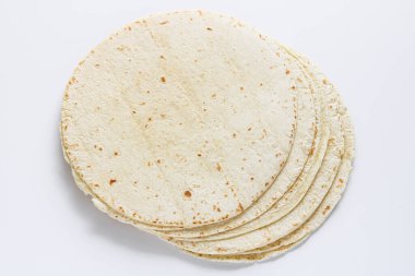 Temiz beyaz arkaplana yerleştirilmiş tortilla ambalajları yumuşak dokularını ve ışıklarını, benekli yüzeylerini vurguluyor..