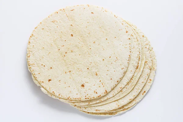 Temiz beyaz arkaplana yerleştirilmiş tortilla ambalajları yumuşak dokularını ve ışıklarını, benekli yüzeylerini vurguluyor..