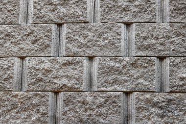 Tekdüze bir düzen ve nötr gri tonlar içeren desenli taş blok duvar. Katı, doğal bir yüzey gerektiren arka plan kullanımı, kentsel mimari görseller ve tasarım projeleri için mükemmel.