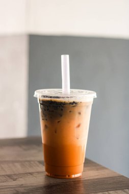 Serinletici bir fincan jöleli Tayland çayı, canlı turuncu tonu ve soğuk bir içecek sunan görünen buz..