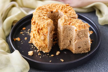 Hafif ve havadar bir Chiffon Cake 'e yakın. Bol miktarda bisküvi kırıntısı ile birlikte. Pastanın klasik bir halka şekli var. İçini gösteren bir dilim çıkarılmış..