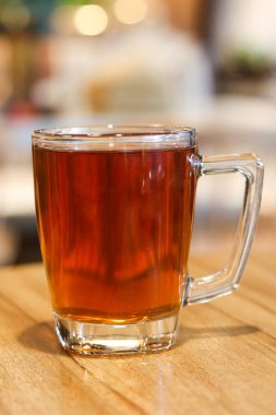 Tahta bir yüzeyde bir bardak sıcak çayın portresi..