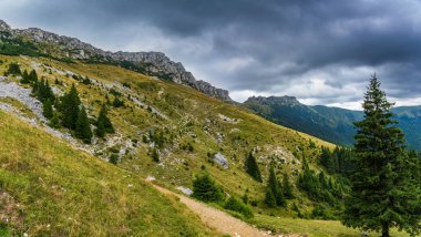 A stunning autumn landscape in the Bucegi Mountains, showcasing the Coltii Tapului mountain ridge. The vibrant fall colors paint the rugged terrain