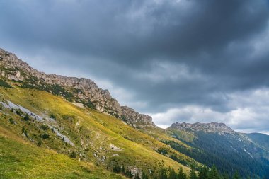 A stunning autumn landscape in the Bucegi Mountains, showcasing the Coltii Tapului mountain ridge. The vibrant fall colors paint the rugged terrain