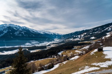 A breathtaking winter sunset near Kaprun, Austria, bathes the snow-covered mountains in golden and pink hues, as the crisp alpine air and serene lands
