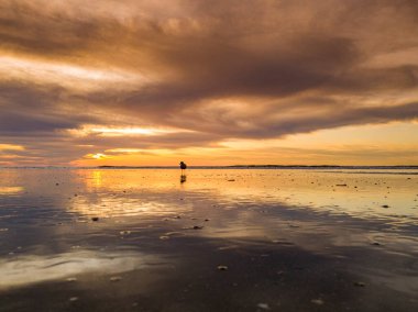 Hollanda, Petten yakınlarındaki Kuzey Denizi 'nin üzerine altın renkleri serpiştirerek, büyüleyici bir renk senfonisi ile gökyüzünü boyuyor.