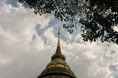 Düşük açılı fotoğraf tamamen anıtsal bir Budist olan Chedi 'nin (stupa) üst kısmına odaklandı. Perspektif yukarıya doğru bakıyor, bu da yüksekliği ve dikeyliği vurguluyor.