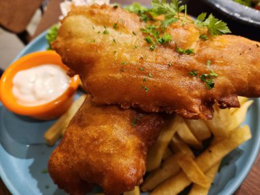 Patates kızartması ve kremalı soslu kızarmış balık filetosu.