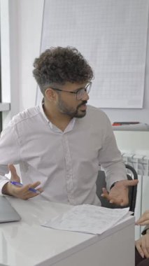 Ortağına bir iş planı belgesini açıklarken konsantre erkek girişimci el kol hareketi yapıyor