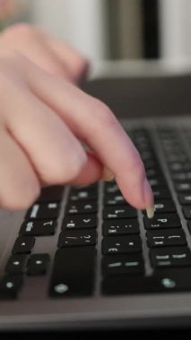 Laptop klavyesinde yazı yazan, geceleri bilgisayarda çalışan kadın parmaklarının yakın çekimi.