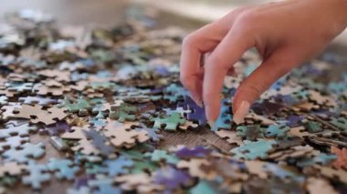 Kadın eli, yapboz parçalarının arasından doğru parçayı arıyor.